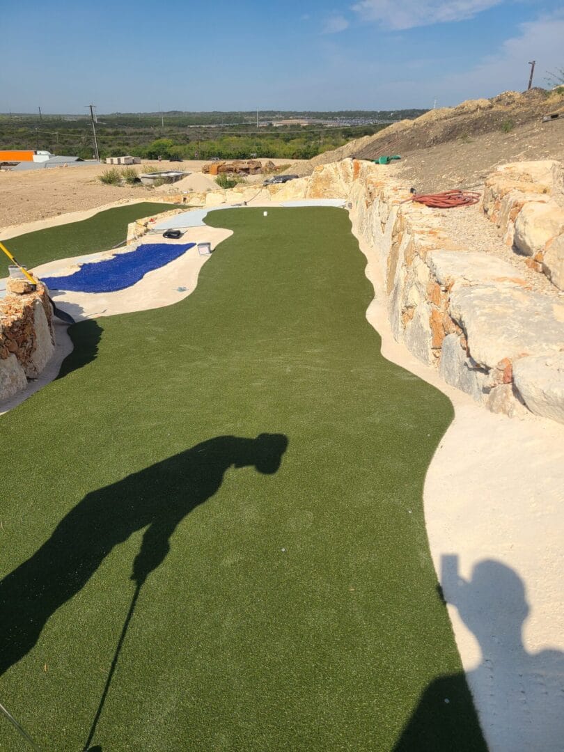 An unfinished putting lane and water feature liner during construction.